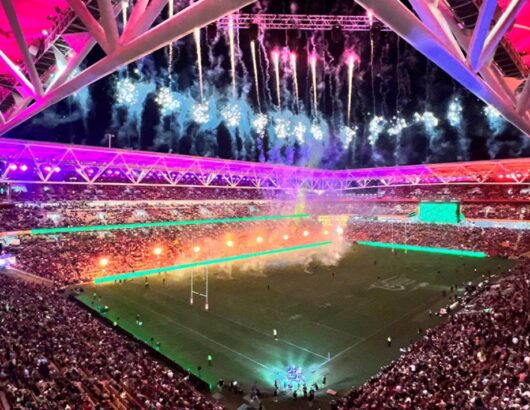 Rugby stadium full of fans lit up with fireworks