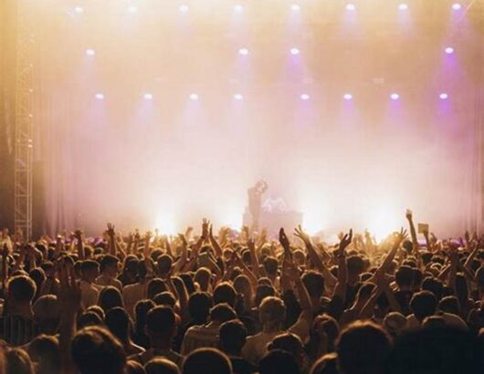 Large crowd in front of a lit performing stage