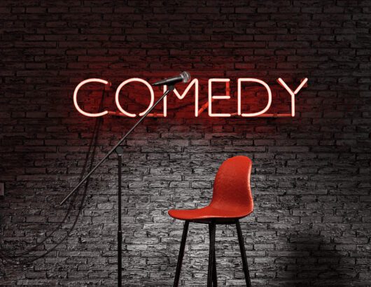 The image of the lighte up "comedy" sign
